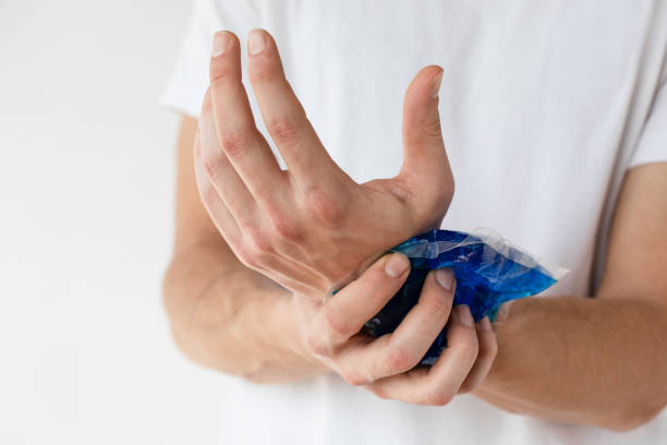 Man holds an icepack to his wrist for pain relief from Carpal Tunnel Syndrome.